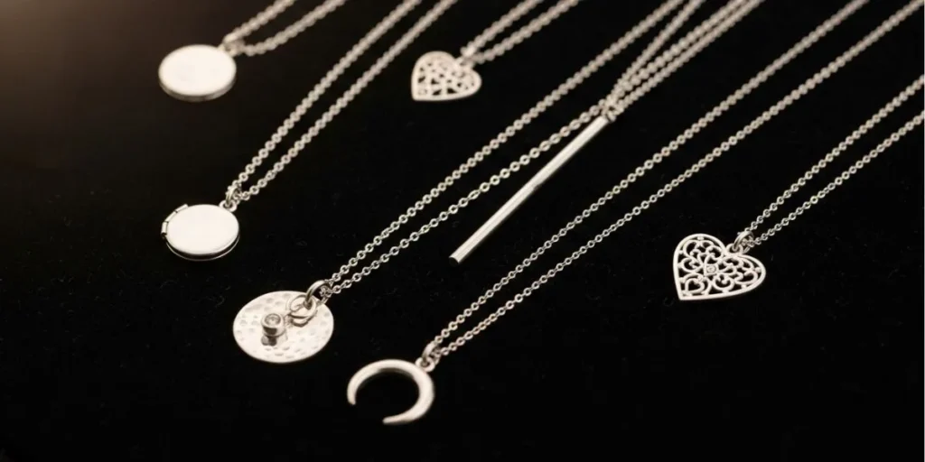 مجموعه‌ای از انواع مدل گردنبند نقره زنانه با آویزهای متنوع طرح قلب، ماه و دایره.